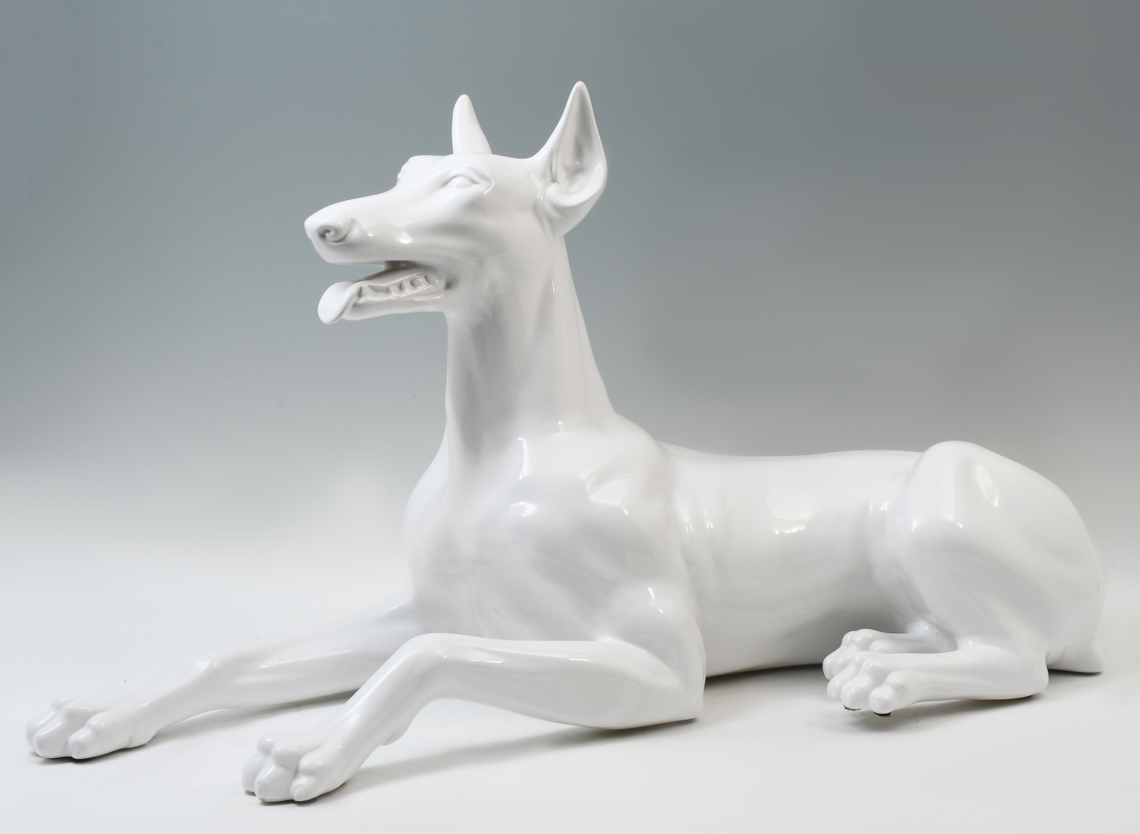 Appraisal: LIFE SIZED RECUMBENT DOBERMAN STATUE Large recumbent porcelain Doberman statue