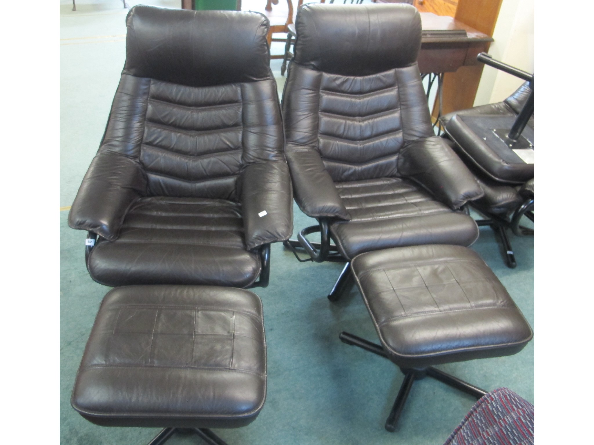 Appraisal: A pair of leather swivel chairs and foot stools