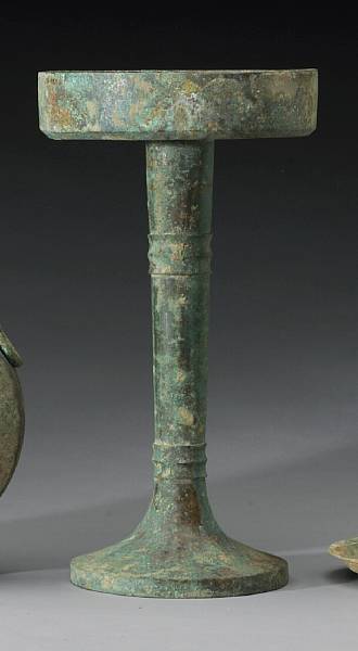 Appraisal: A tall bronze lamp Han Dynasty Its cup-shaped mouth centered