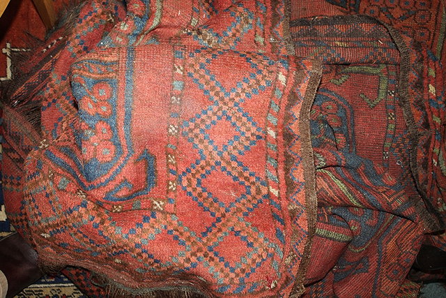 Appraisal: A LARGE AFGHAN RED GROUND CARPET with geometric medallions