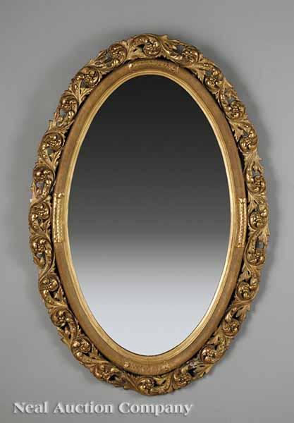 Appraisal: An American Rococo Carved and Giltwood Mirror th c oval