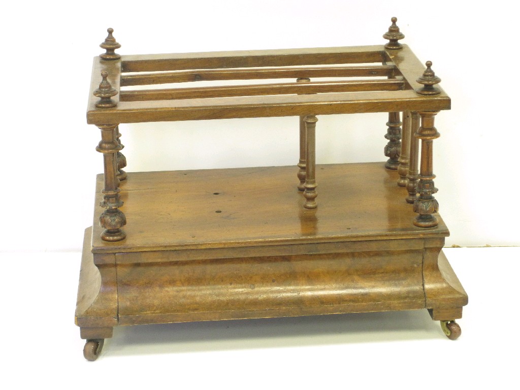 Appraisal: A Victorian walnut Canterbury with spindle turned divisions drawer to