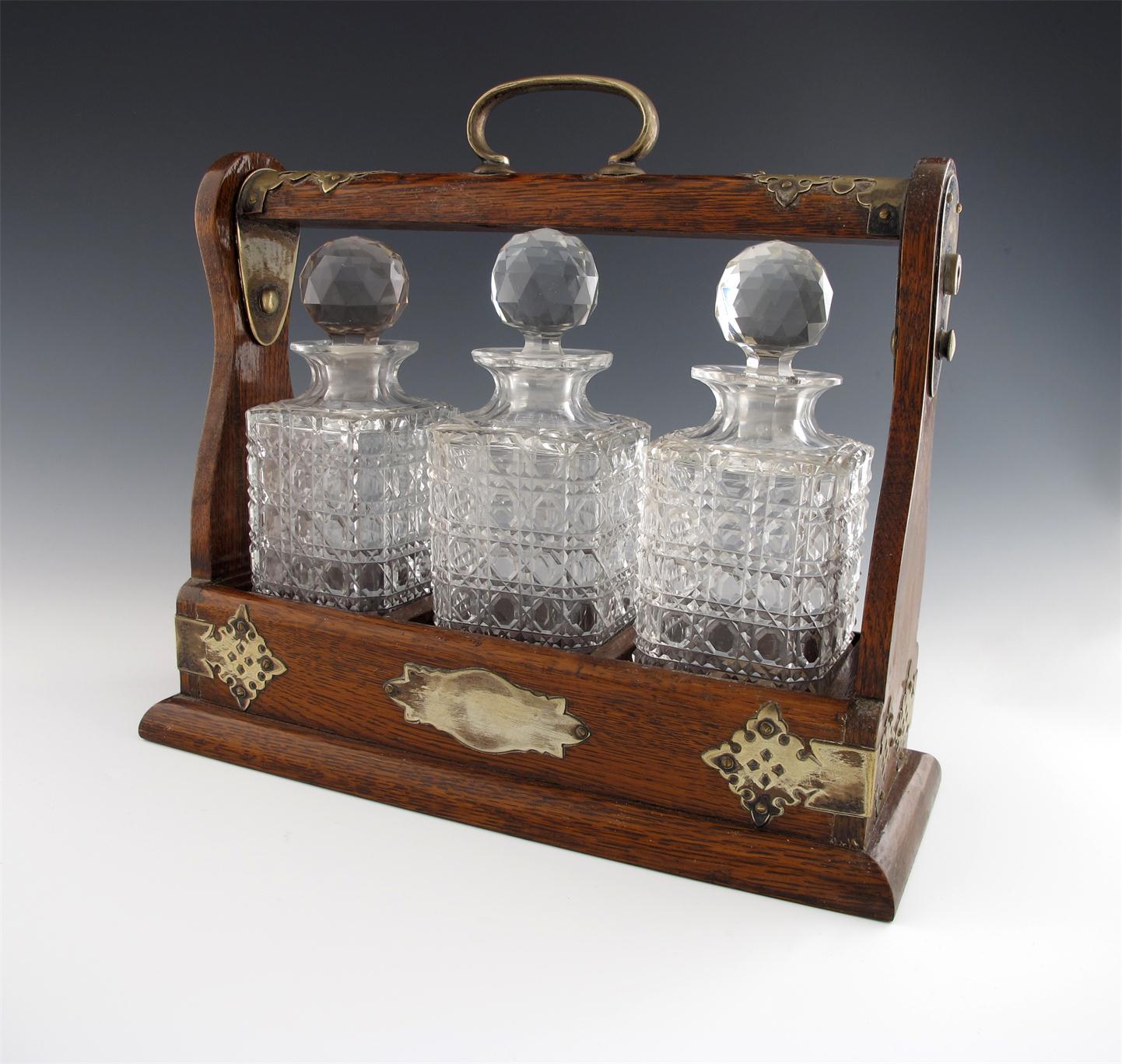 Appraisal: An electroplated three-bottle oak tantalus