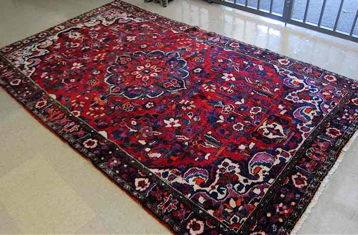 Appraisal: PERSIAN TRIBAL CARPET floral and central floral lozenge design on