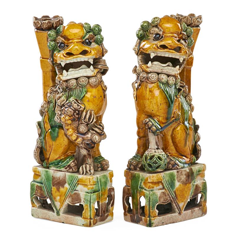 Appraisal: PAIR OF CHINESE POTTERY JOSS STICK HOLDERS Glazed foo dogs