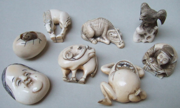 Appraisal: A group of eight ivory netsuke comprising a recumbent ox