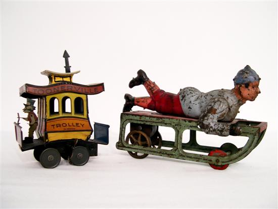 Appraisal: Two early s tin toys a boy on a sled