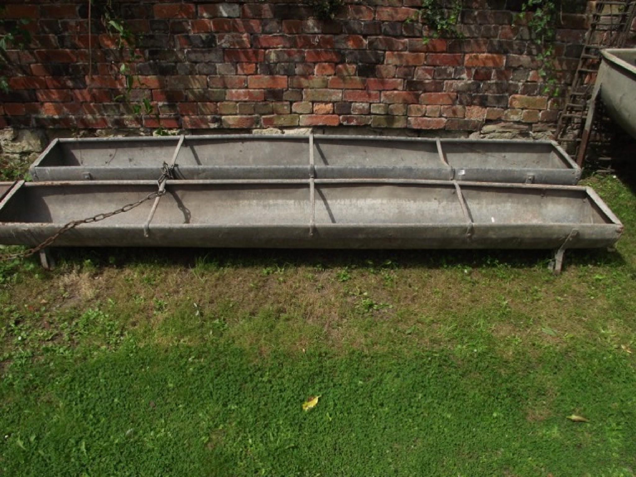 Appraisal: Two similar galvanised steel three rung divisioned feeding troughs of