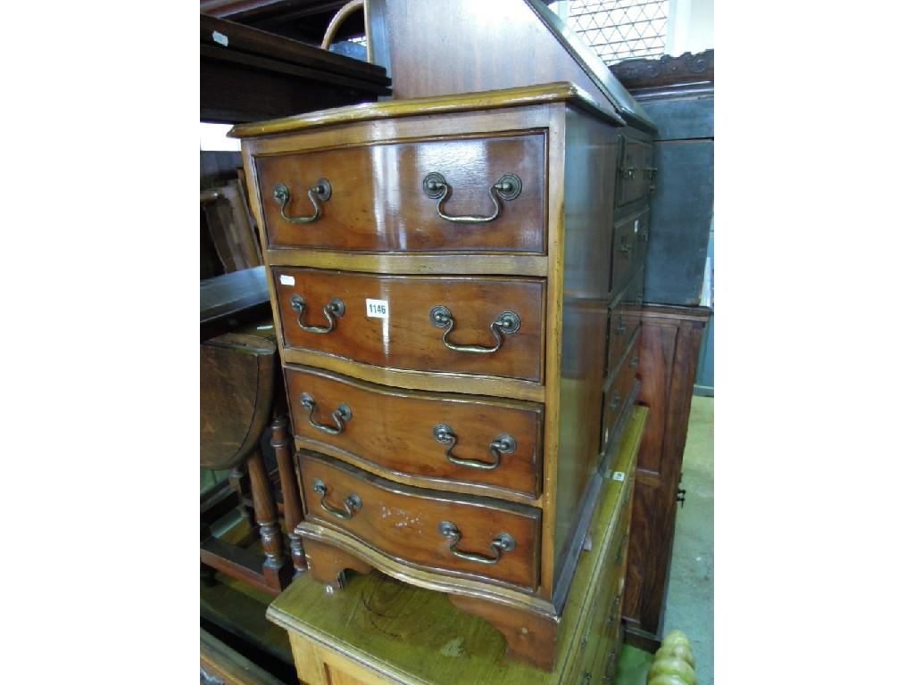 Appraisal: A small reproduction yew wood veneer serpentine chest fitted with