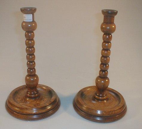 Appraisal: A pair of early thC oak bobbin turned candlesticks with