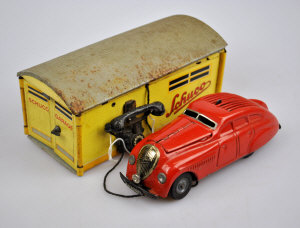 Appraisal: A Schuco tinplate garage with Kommando Anno clockwork car red