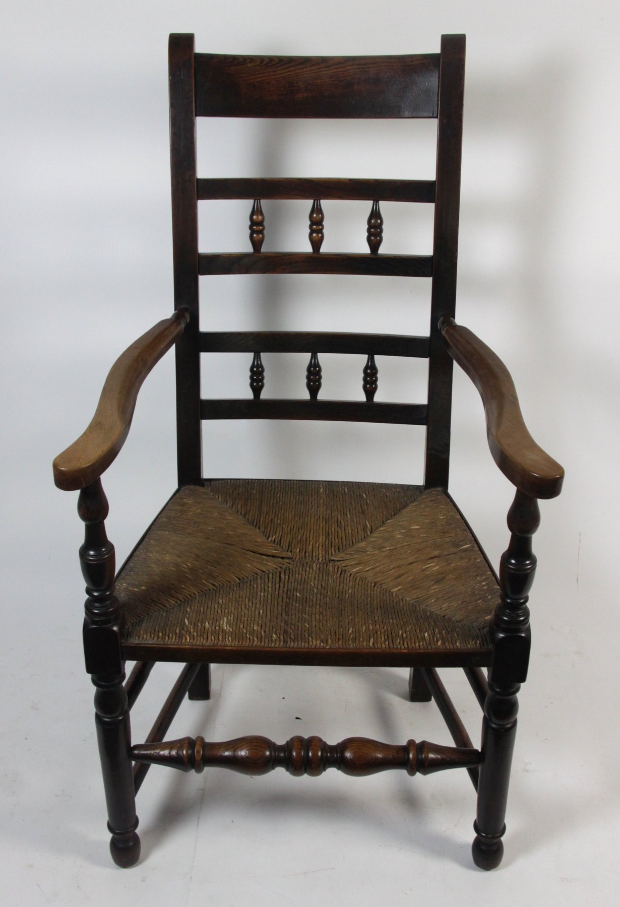 Appraisal: A Lancashire spindle back armchair with rush seat