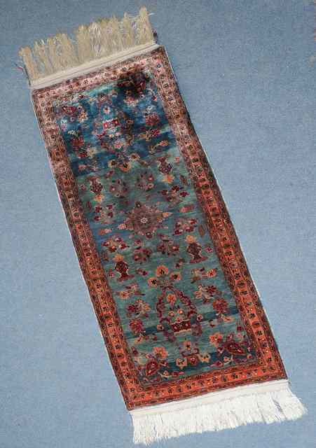 Appraisal: A PERSIAN BLUE GROUND SILK MAT with classical foliate scroll