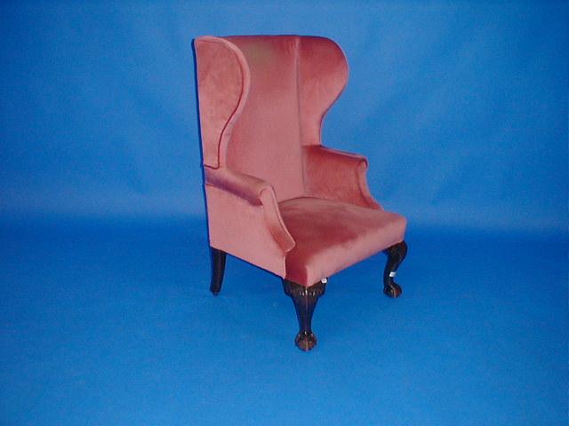 Appraisal: A thC wing armchair upholstered in pink draylon having carved