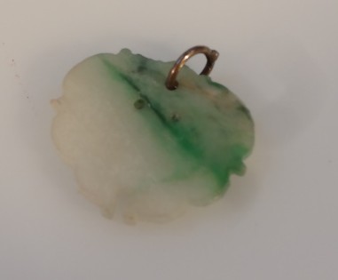 Appraisal: A Chinese pale and green fused jade pendant the oval