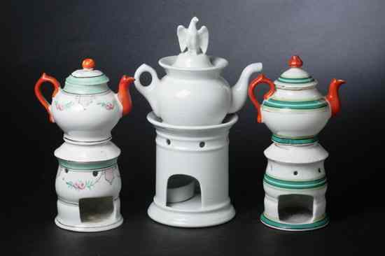 Appraisal: THREE FRENCH PORCELAIN TEAPOTS AND WARMING STANDS Including two Paris