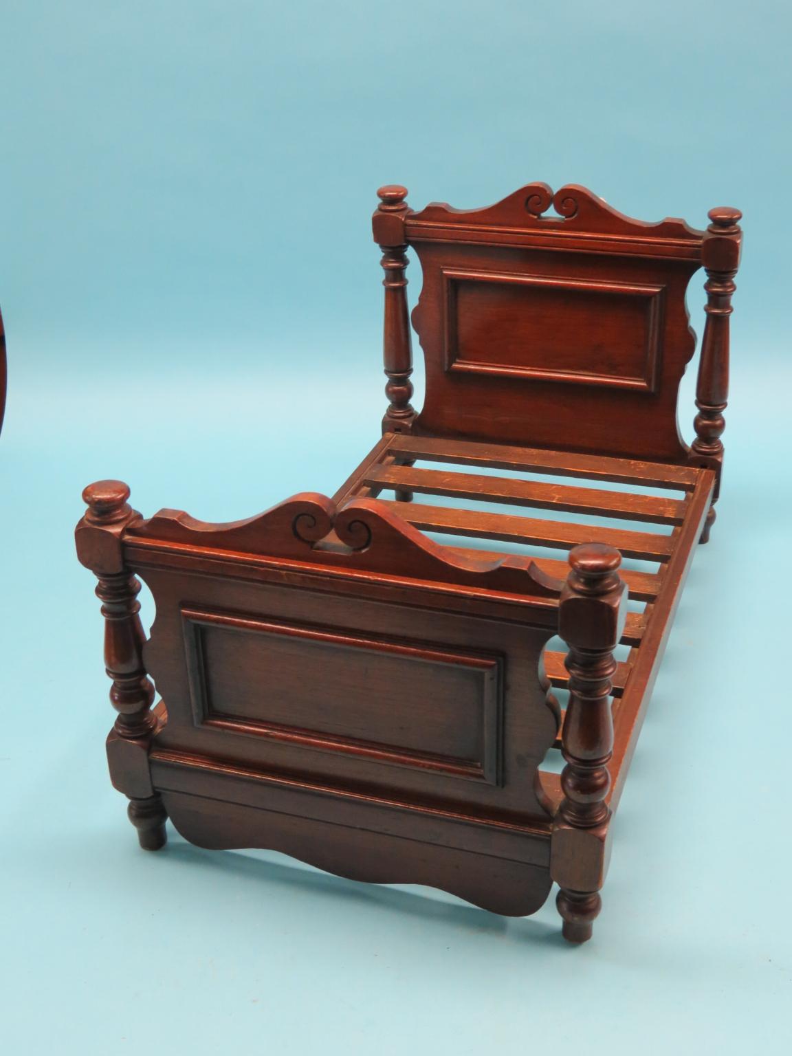 Appraisal: A Victorian walnut miniature bedstead panelled head and foot-boards with