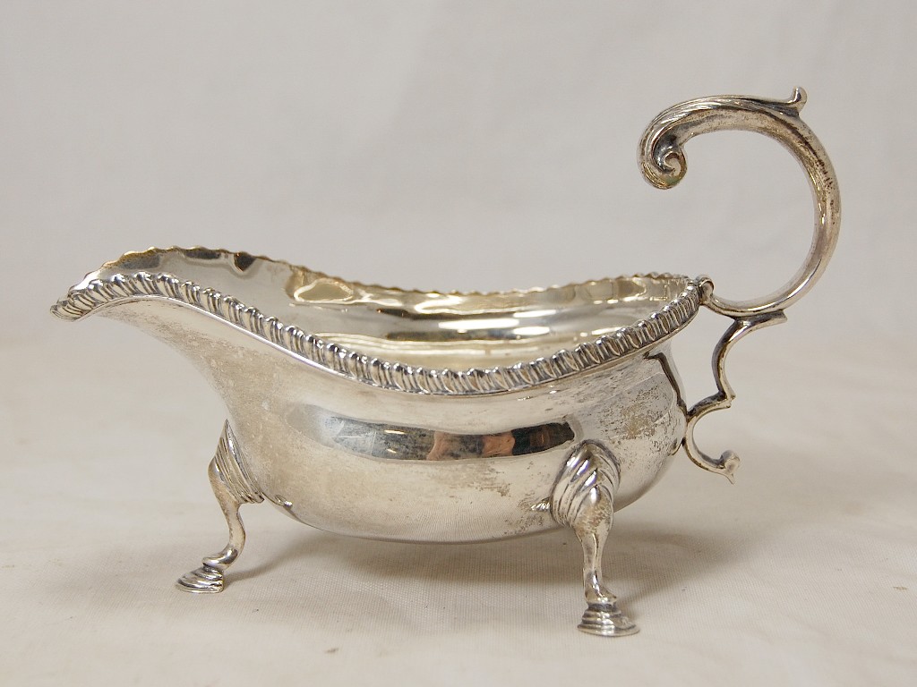 Appraisal: Gadroon-edge silver sauce boat on three hoof feet with flying