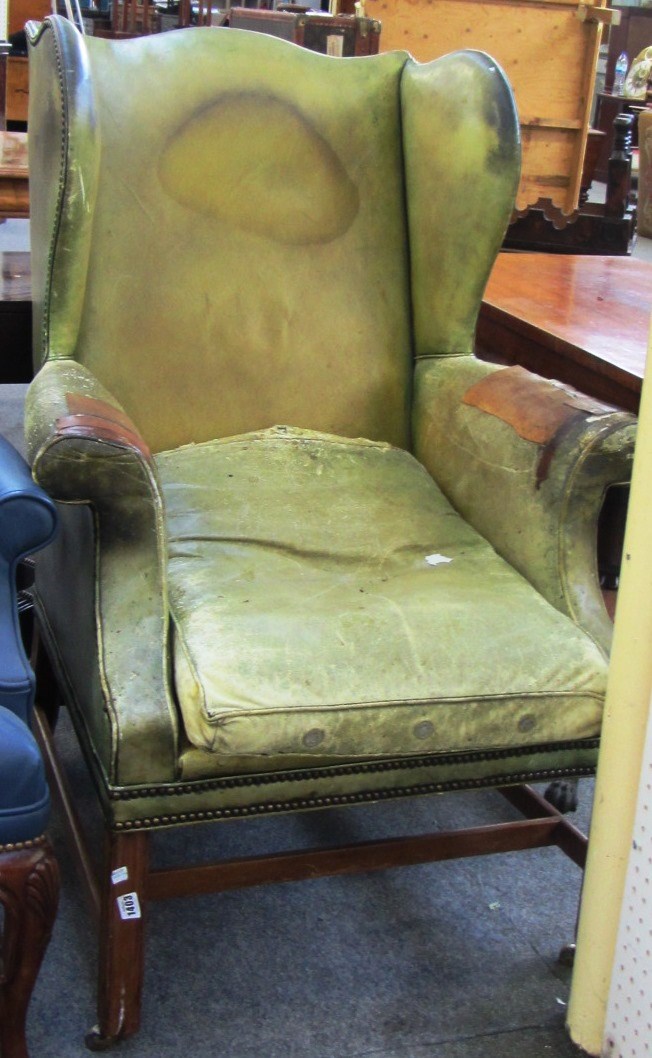 Appraisal: A George III and later green leather upholstered wingback armchair