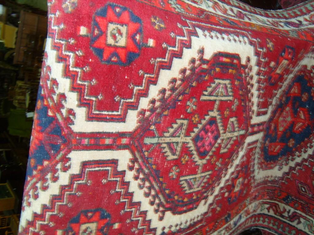 Appraisal: A red ground eastern wool runner with geometric and hook