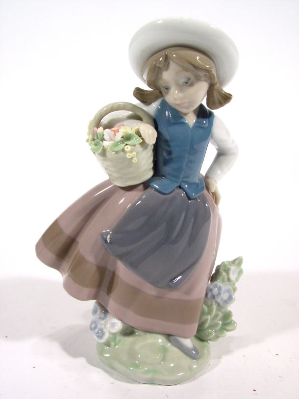 Appraisal: Lladro porcelain figurine clutching a basket of flowers in a