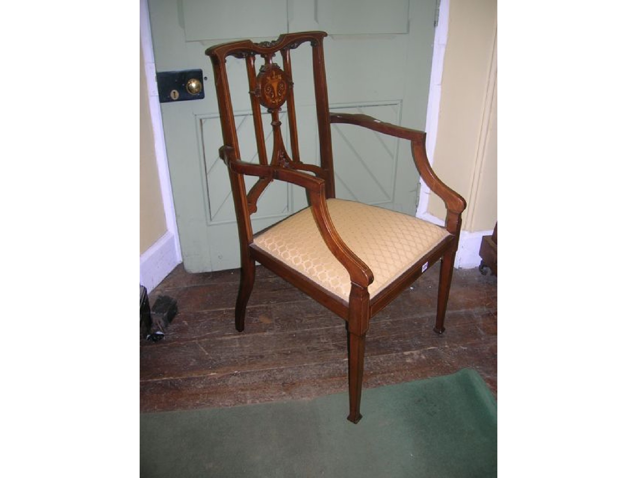 Appraisal: An inlaid Edwardian mahogany elbow chair the central splat with