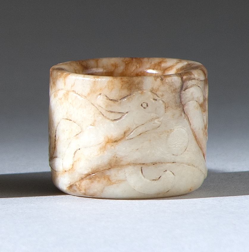 Appraisal: CHICKEN-BONE JADE THUMB RING th CenturyWith stylized qilin carving throughout