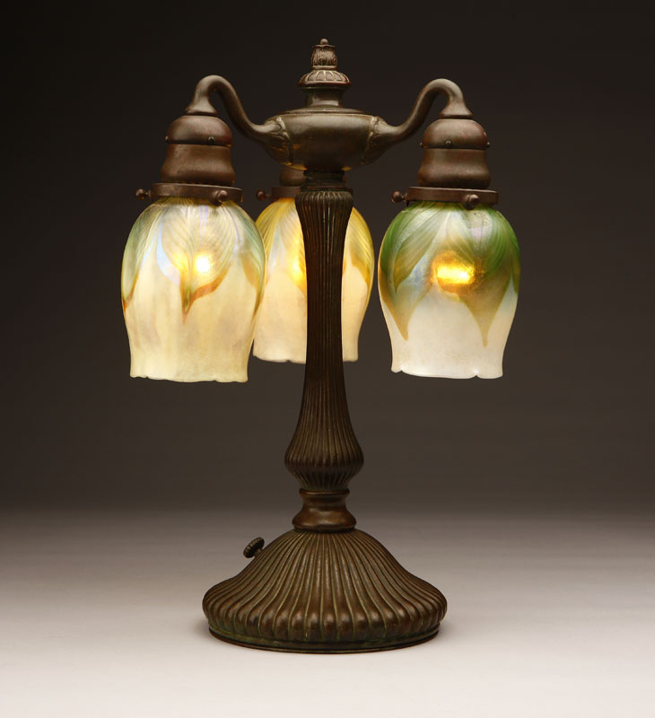 Appraisal: A Tiffany Studios bronze and Favrile art glass three-light table