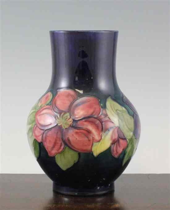 Appraisal: A Moorcroft Clematis pattern vase post-war with a dark blue