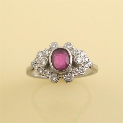 Appraisal: A ruby and diamond cluster ring The oval shape ruby