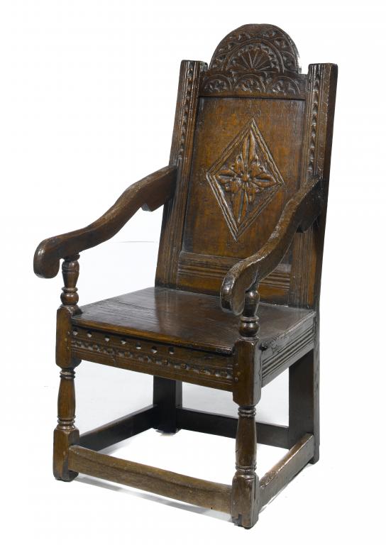 Appraisal: AN OAK PANEL-BACK ARMCHAIR with carved break-arched top rail and