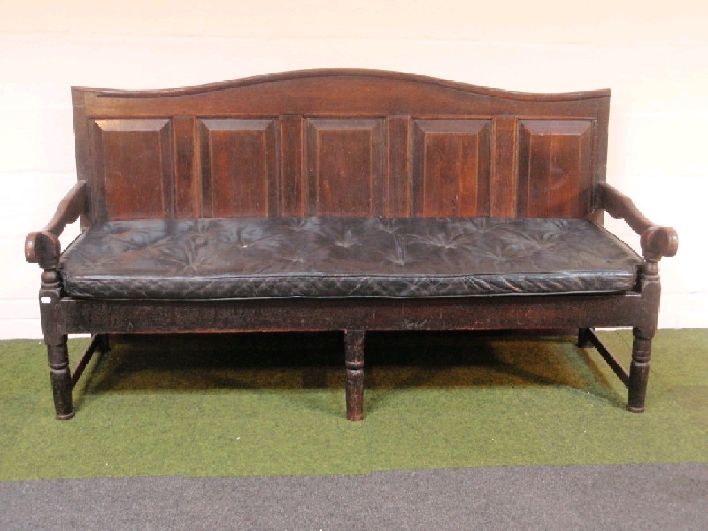 Appraisal: A Georgian oak settle with panelled back and loose cushion