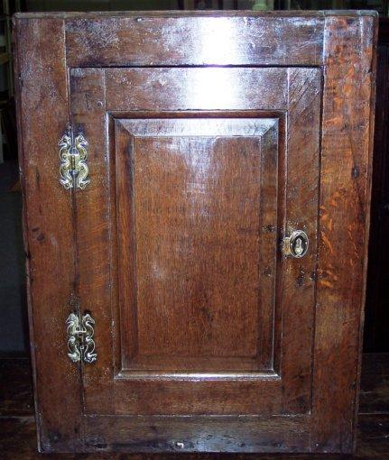 Appraisal: A George II oak hanging corner cupboard with panel door