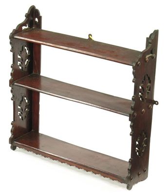 Appraisal: A late Victorian mahogany hanging shelf with pierced end supports