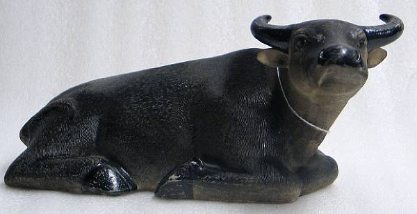 Appraisal: A polychromed ceramic model of a recumbent ox The surface