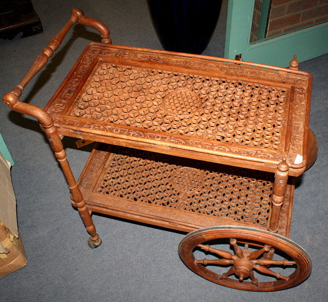 Appraisal: AN INDIAN TEAK TROLLEY with spoked wheels cm long and