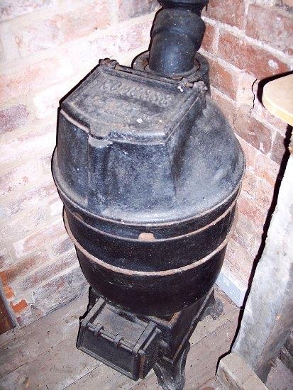 Appraisal: A cast iron stove of barrel form the hinged cover