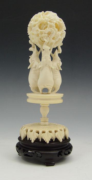 Appraisal: IVORY ELEPHANT STAND WITH MYSTERY BALL Featuring elephants on hind