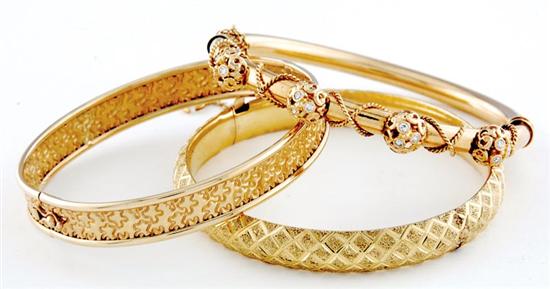 Appraisal: Gold bangle bracelets one is hollow hinged and engraved one