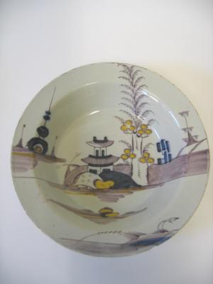 Appraisal: AN ENGLISH DELFT DISH polychrome painted with chinoiserie river landscape