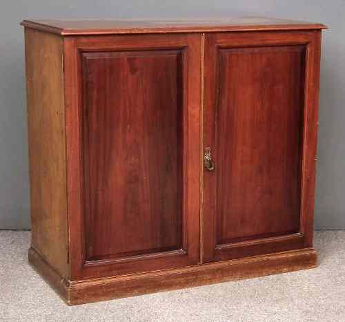 Appraisal: An Edwardian mahogany cupboard fitted six sliding trays enclosed by