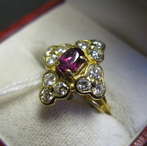 Appraisal: GARNET DIAMOND AND EIGHTEEN KARAT GOLD RING centering an oval-cut