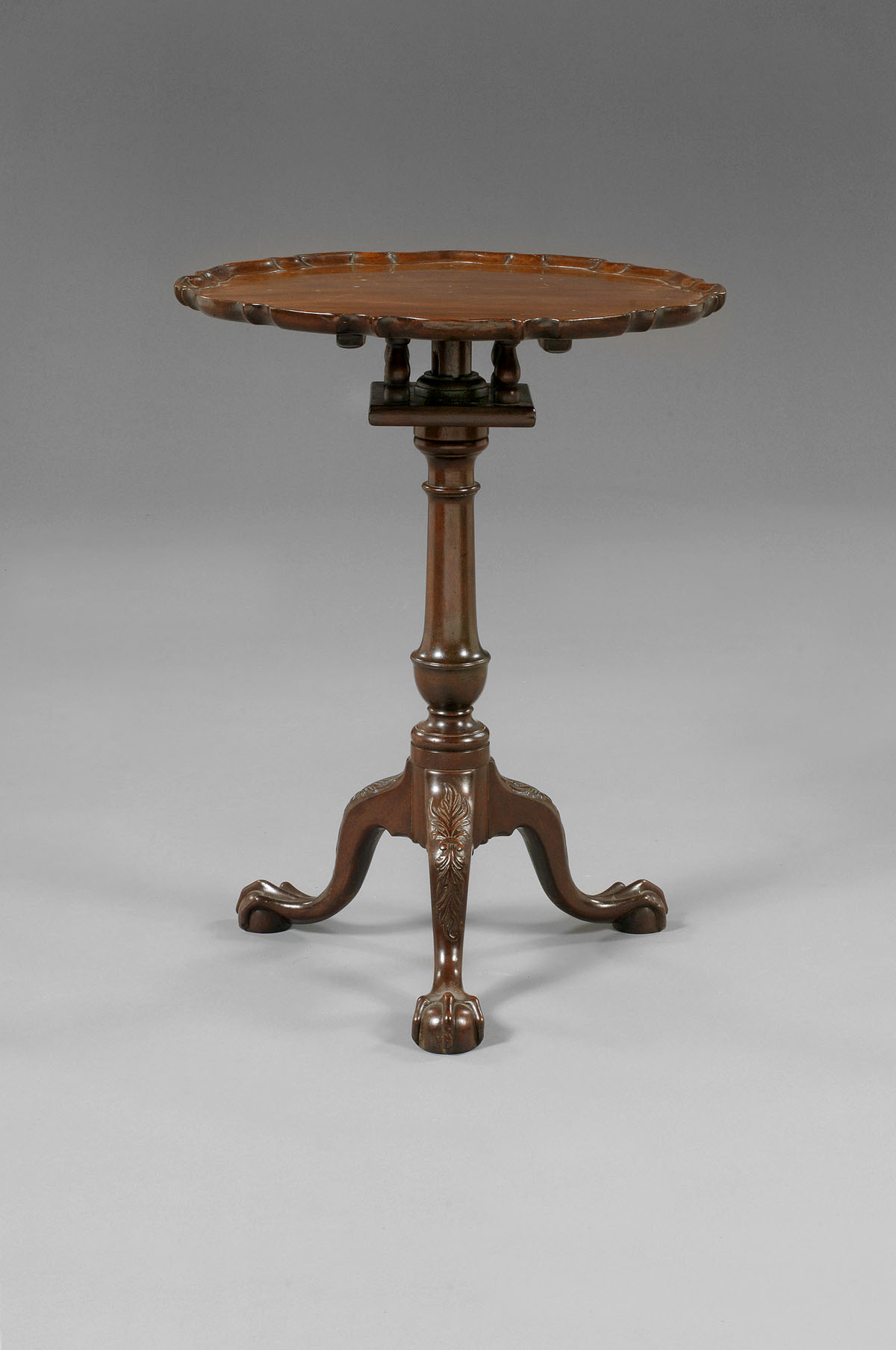 Appraisal: CHIPPENDALE MAHOGANY TILT TOP CANDLESTAND The scalloped edge top tilting