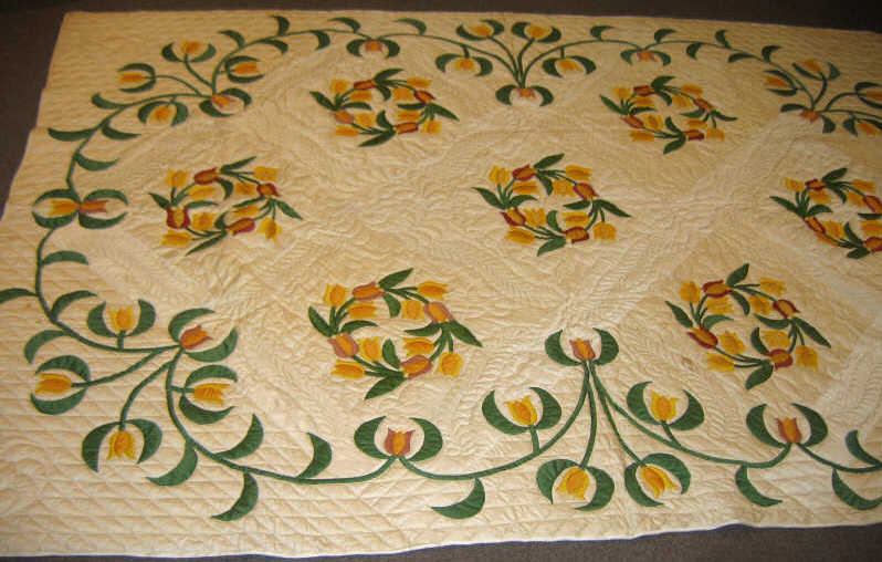 Appraisal: PAIR OF AMERICAN 'TULIP APPLIQUE' QUILTS Sewn flowering wreath within