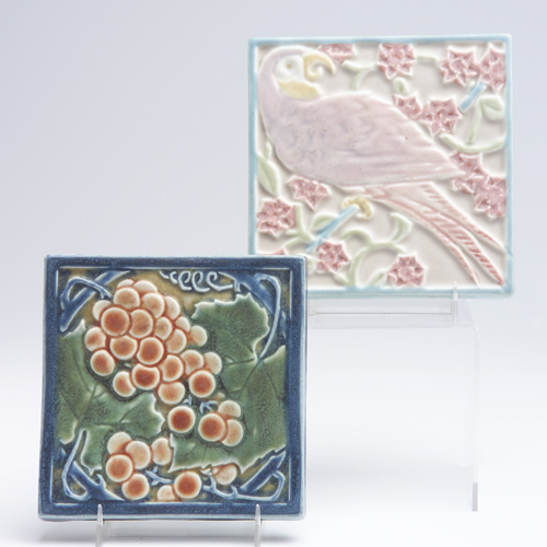 Appraisal: ROOKWOOD Two trivet tiles one with a mauve parrot with