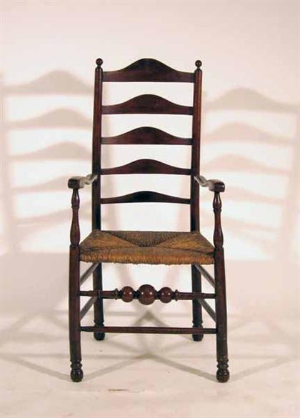 Appraisal: Ladderback arm chair th century With four arched slats joined