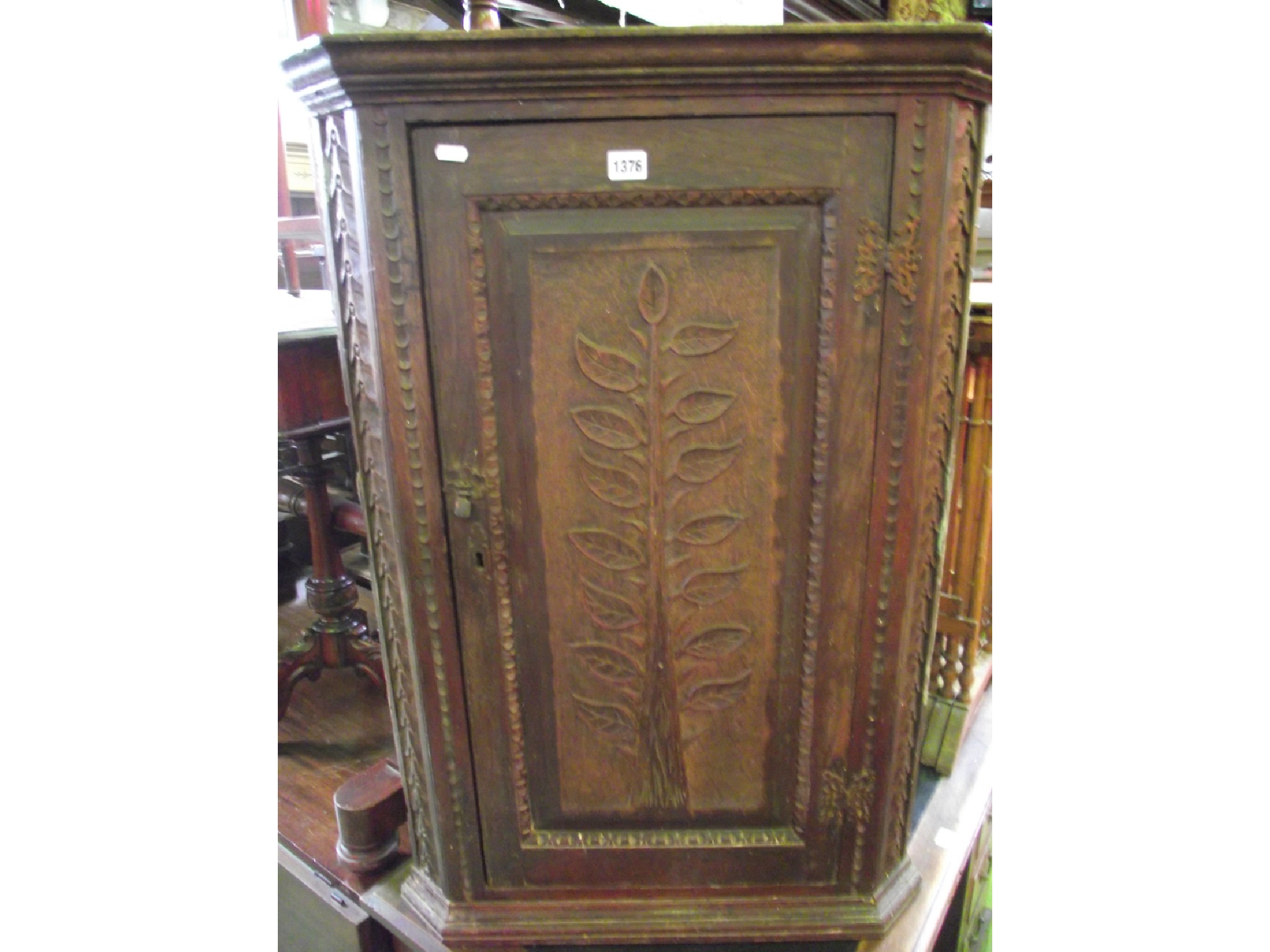 Appraisal: A th century oak hanging corner cupboard with carved trailing