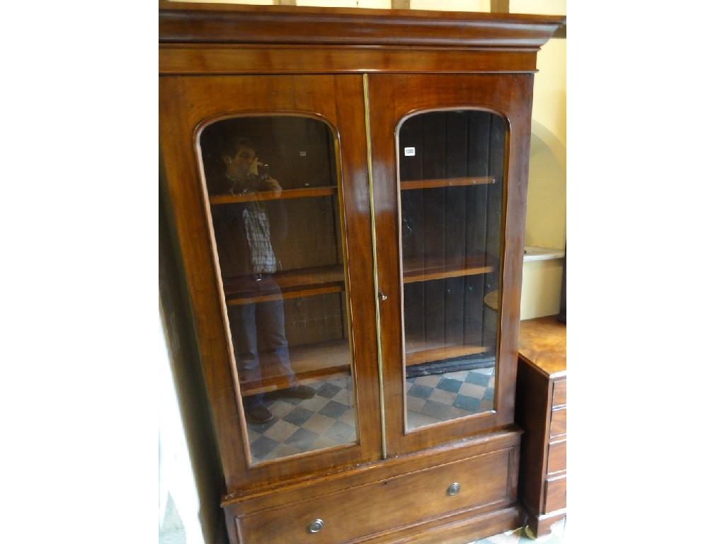 Appraisal: A mahogany bookcase with shaped cornice over a pair of