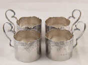 Appraisal: Four silver teaglass holders with scrolling handles and shaped chased