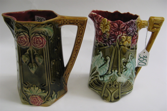 Appraisal: TWO FRENCH MAJOLICA ART NOUVEAU PITCHERS ornately decorated with repousse